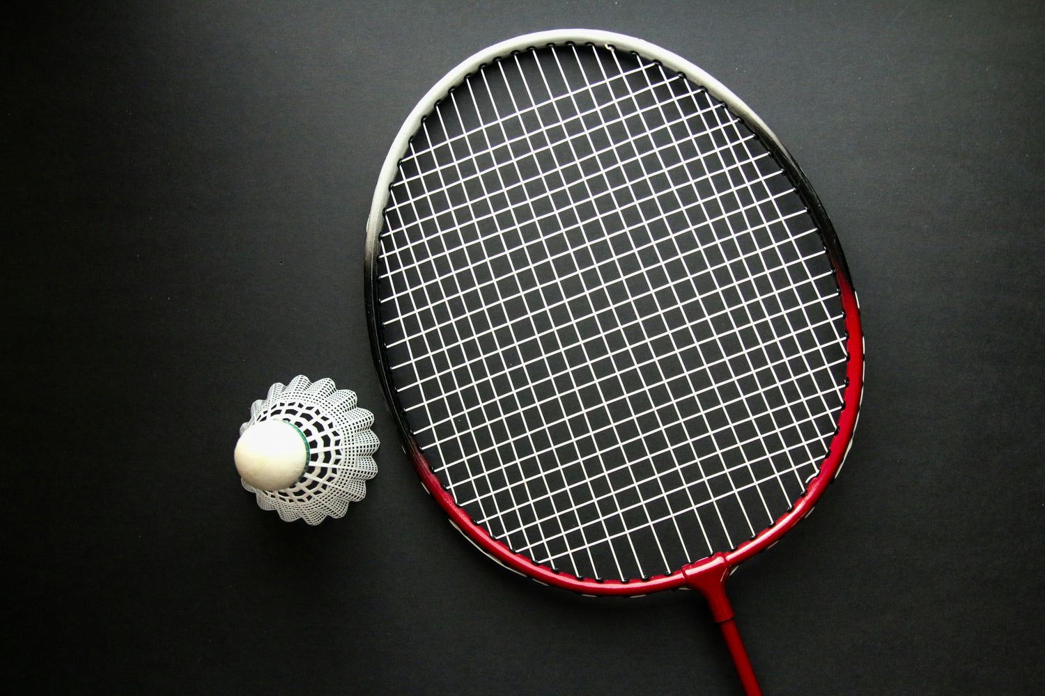Red, black and white badminton racket with shuttlecock.